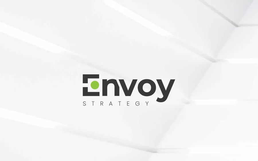 A first-round logo option: “Envoy” in a heavy lowercase with a green dot set into a square E, and STRATEGY spaced out beneath.